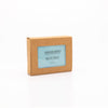 Photo of a vegan, facial and body cleansing bar shown in sustainable packaging.