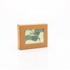 Photo of a white and green swirled colored, vegan, facial and body cleansing bar shown in sustainable packaging.